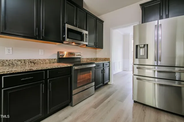 a kitchen with a sink stainless steel appliances and cabinets