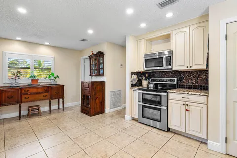 a kitchen with white cabinets and refrigerator