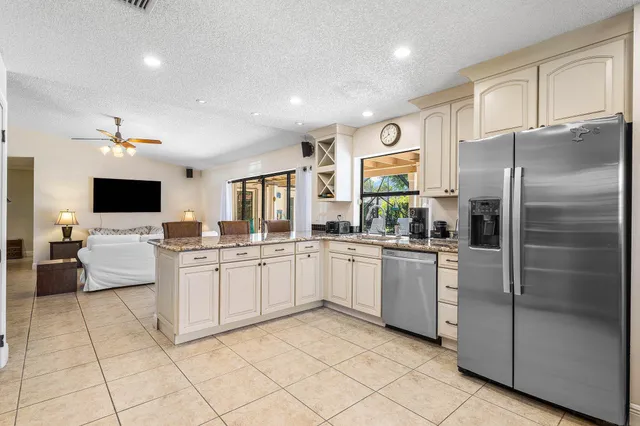 a large kitchen with a large counter top stainless steel appliances and cabinets