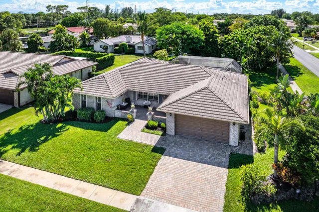 a view of house with garden and swimming pool