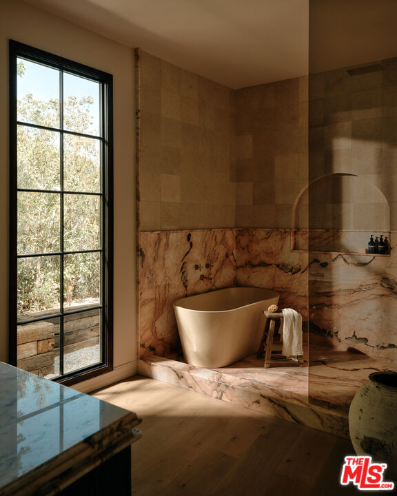 11945 Lockridge Road Studio City, CA 91604 - Photo 17 of 36 a room with a chair and a potted plant next to a window