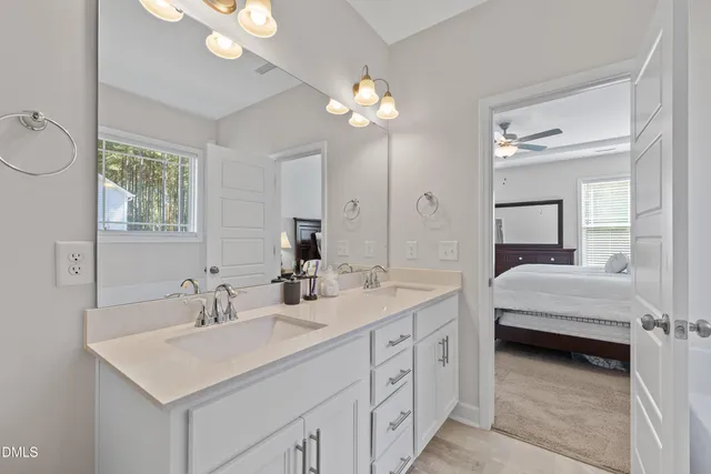 a en suite bathroom with a double vanity sink a mirror and a shower