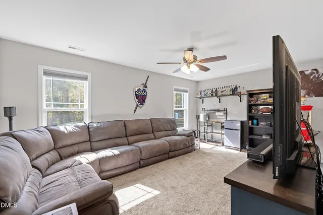 a living room with furniture a window and a flat screen tv