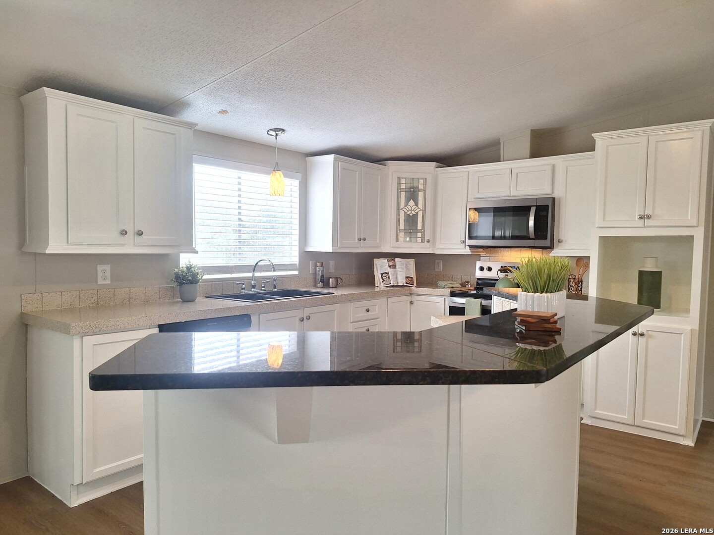 533 Las Hadas Spring Branch, TX 78070 - Photo 3 of 16 a kitchen with granite countertop a sink a stove top oven a counter space and cabinets