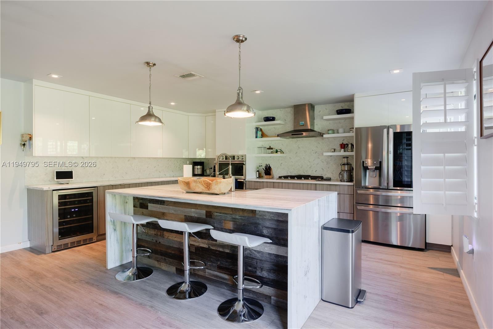 6201 Southwest 36th Street Miami, FL 33155 - Photo 26 of 43 a kitchen with stainless steel appliances kitchen island granite countertop a stove a sink a refrigerator and chairs