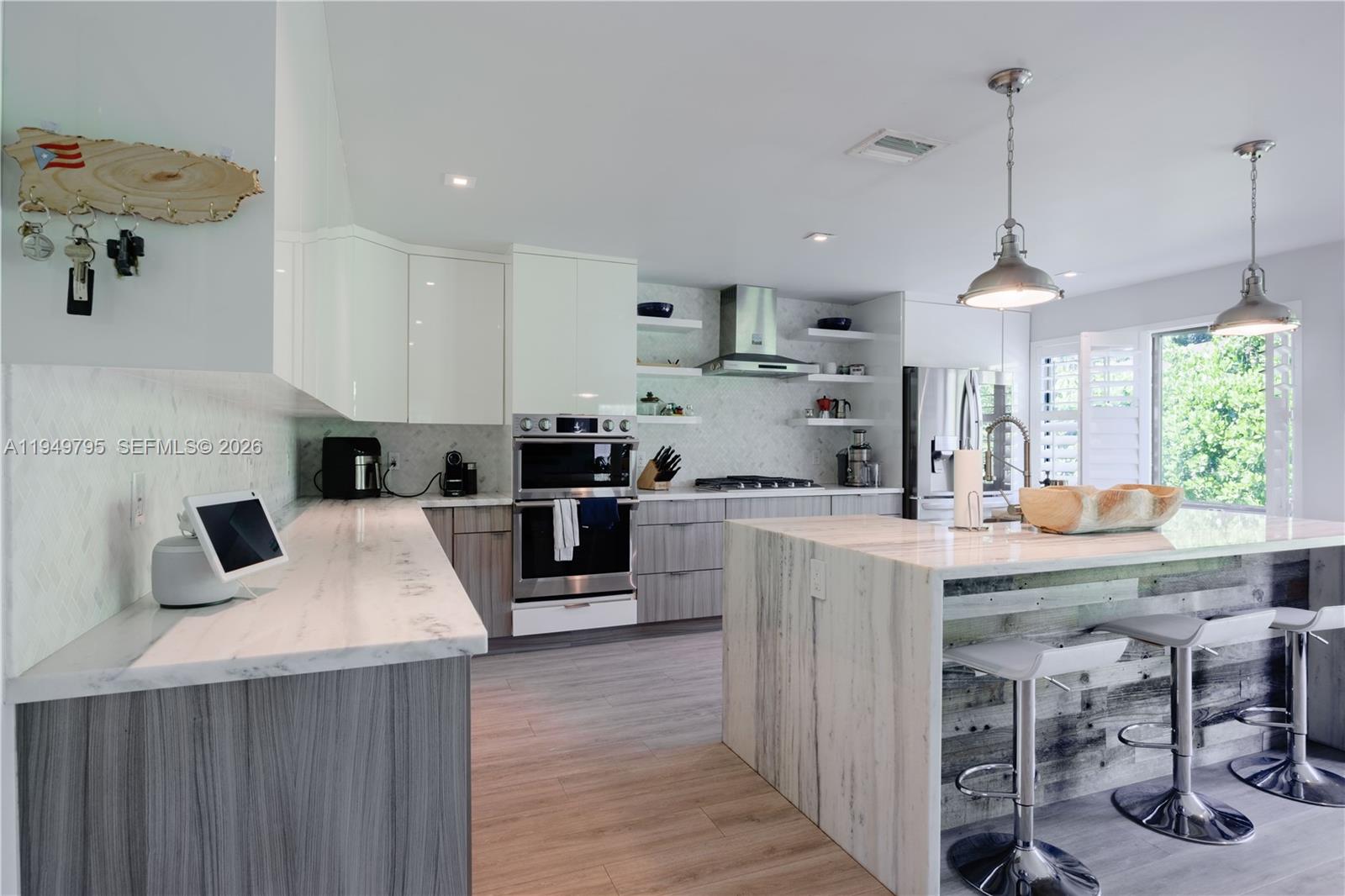 6201 Southwest 36th Street Miami, FL 33155 - Photo 27 of 43 a kitchen with kitchen island a sink a stove a refrigerator and chairs