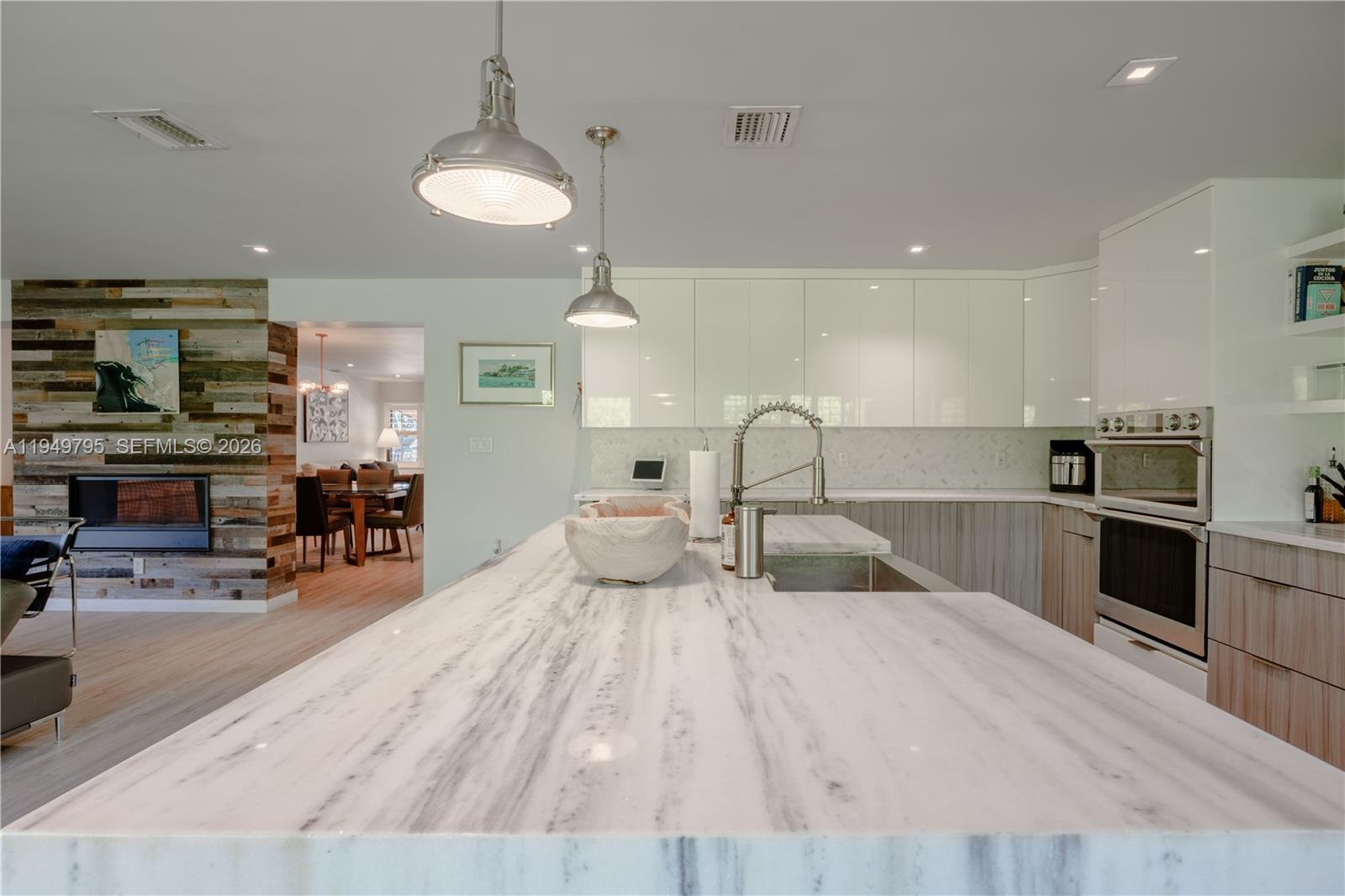 6201 Southwest 36th Street Miami, FL 33155 - Photo 29 of 43 a large kitchen with stainless steel appliances a stove a sink a oven a dining table and chairs with wooden floor