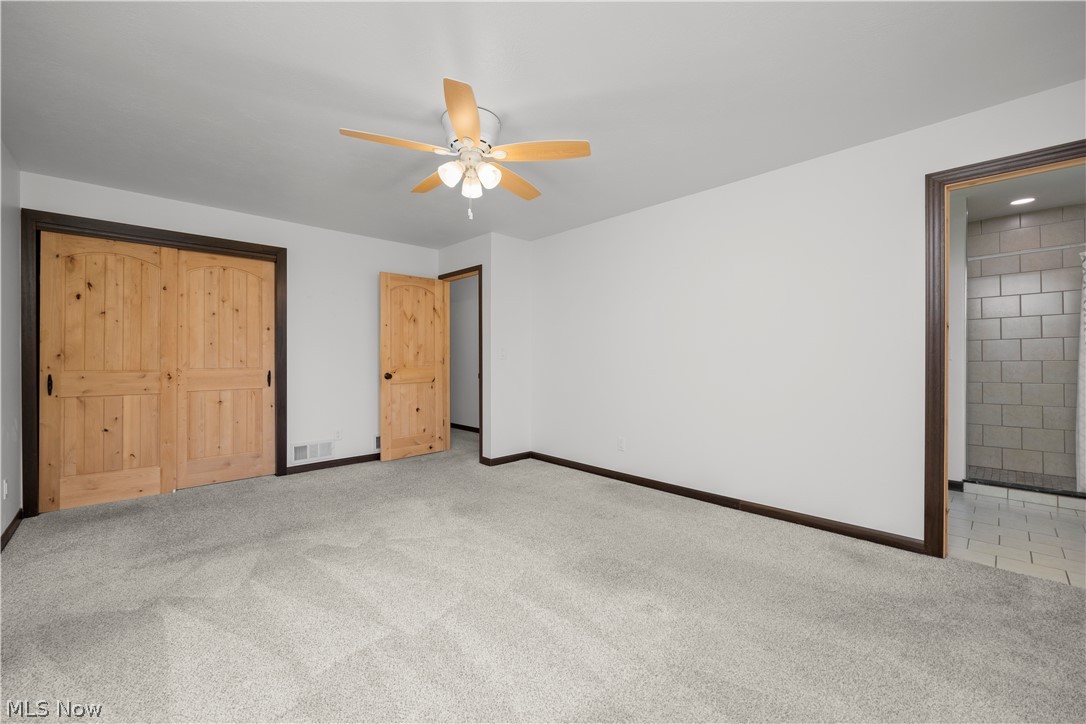 6760 Mason Road Berlin Heights, OH 44814 - Photo 17 of 49 Unfurnished bedroom featuring light carpet, a ceiling fan, and a closet