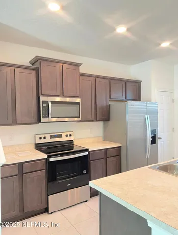 a kitchen with stainless steel appliances a stove a sink a refrigerator and cabinets