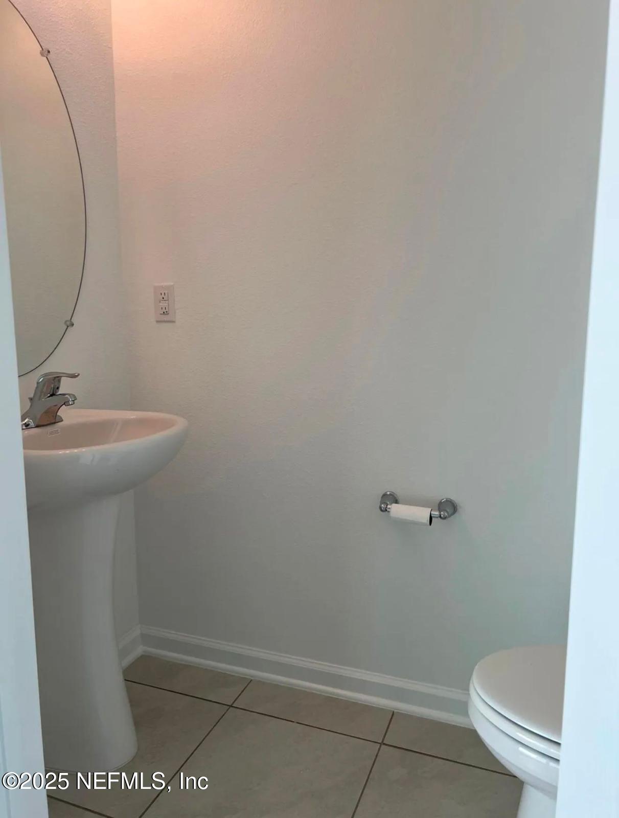 8368 Retrograde Road Jacksonville, FL 32256 - Photo 7 of 16 a bathroom with a sink a toilet and a mirror