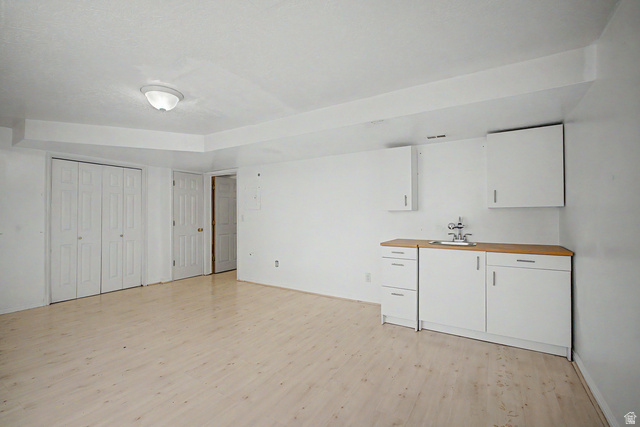 2058 California Avenue, Unit 2 Provo, UT 84606 - Photo 14 of 32 Open space featuring wood-finish flooring, a functional wet bar with wood-finish countertop, and white cabinetry