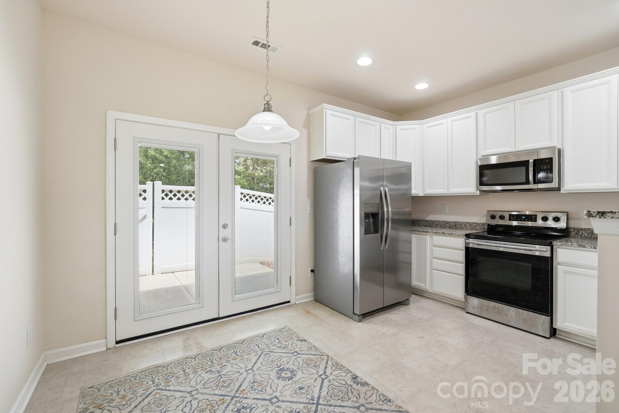 175 Limerick Road, Unit B Mooresville, NC 28115 - Photo 13 of 30 a kitchen with stainless steel appliances granite countertop a refrigerator a stove a microwave and a window