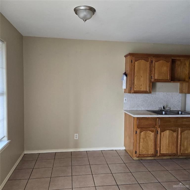 3915 South Alamo Road, Unit 10 Edinburg, TX 78542 - Photo 3 of 9 Kitchen featuring light tile patterned floors, backsplash, and sink