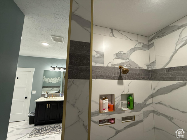 1240 West 2360 North Helper, UT 84526 - Photo 36 of 79 Bathroom with a textured ceiling, visible vents, marble finish floor, a marble finish shower, and vanity
