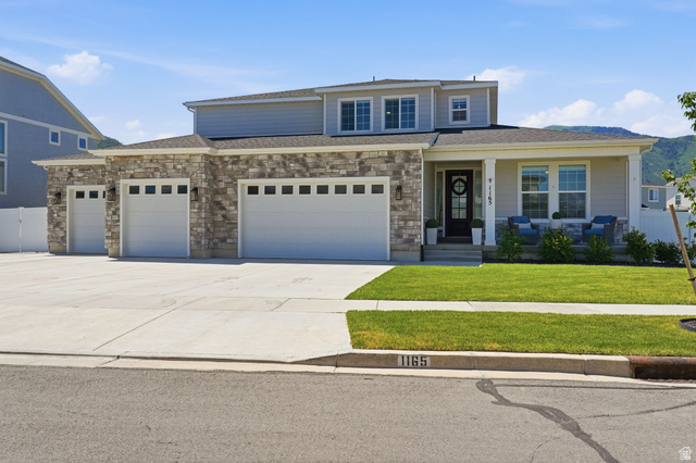 1165 West Union Bench Drive Mapleton, UT 84664 - Photo 59 of 61 Two-story residence featuring a stone and siding exterior, a covered front porch, and a three-car garage