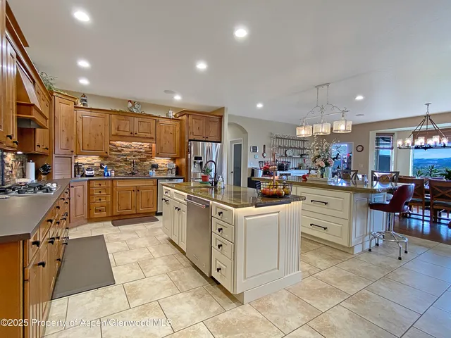 a living room with furniture a fireplace and a chandelier