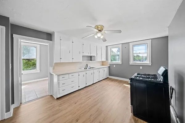 a kitchen with a stove a sink and a window