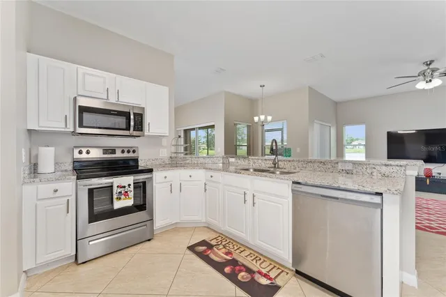 a kitchen with stainless steel appliances granite countertop a stove top oven a sink dishwasher and microwave oven