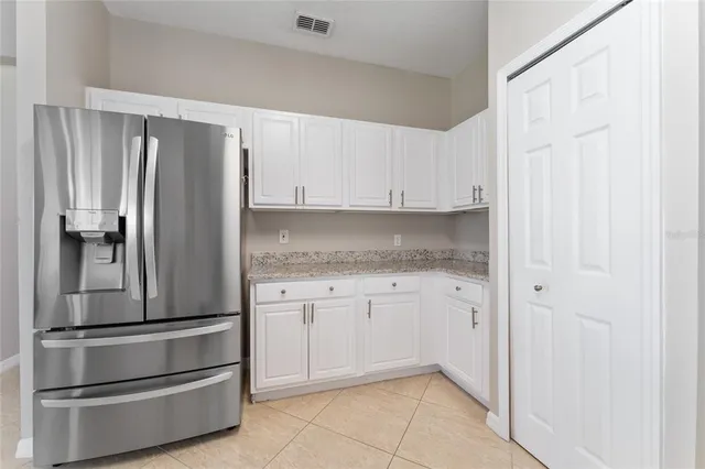 a kitchen with granite countertop white cabinets and stainless steel appliances