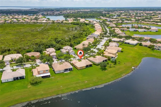 an aerial view of residential houses with outdoor space and trees