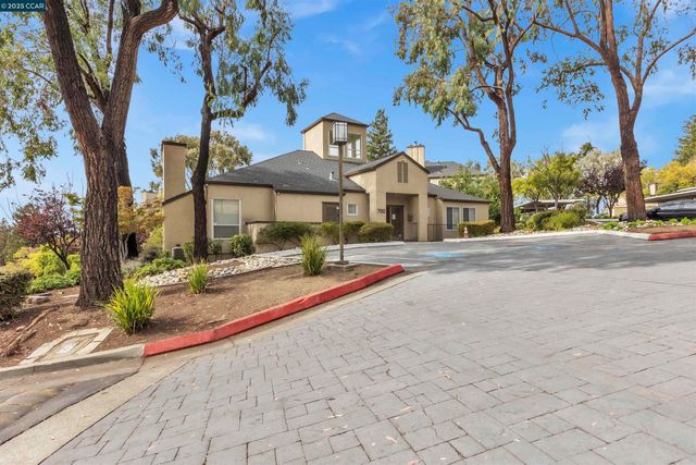a front view of a house with a yard and large trees