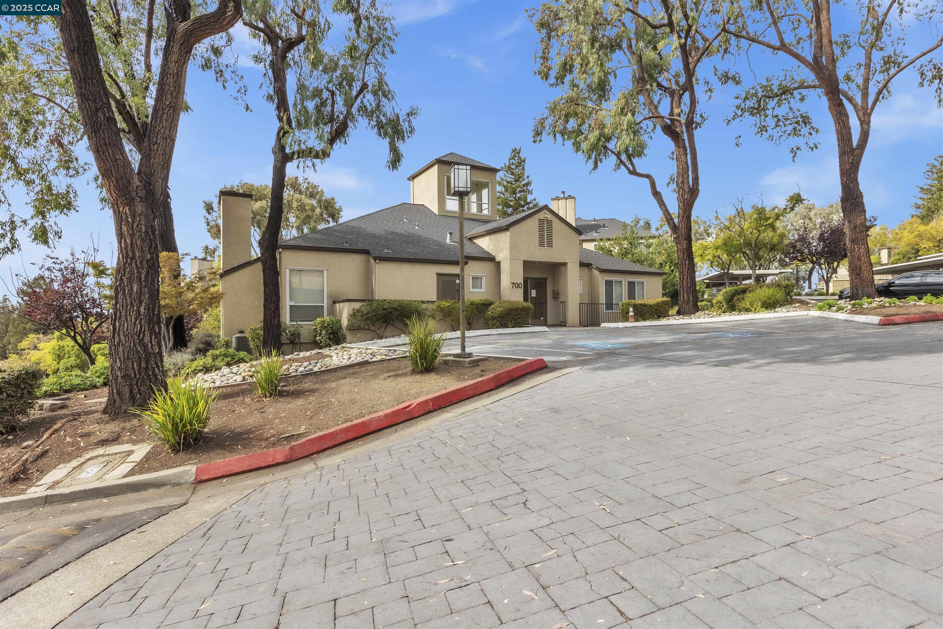 29583 Vanderbilt Street, Unit 310 Hayward, CA 94544 - Photo 16 of 22 a front view of a house with a yard and large trees