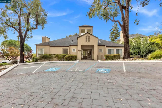a front view of a house with a yard and potted plants