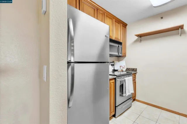 a kitchen with stainless steel appliances granite countertop a refrigerator and a stove