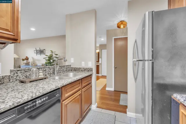 a kitchen with granite countertop a refrigerator and a sink