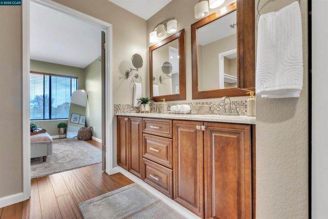 a spacious bathroom with a granite countertop sink and a mirror
