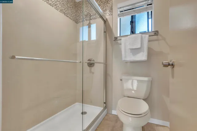 a bathroom with a granite countertop toilet and a bathtub