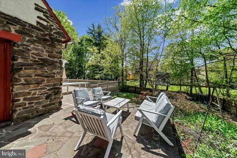 a view of a patio with table and chairs with wooden floor and fence