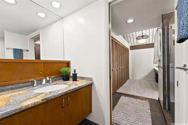 a bathroom with a granite countertop sink and a mirror