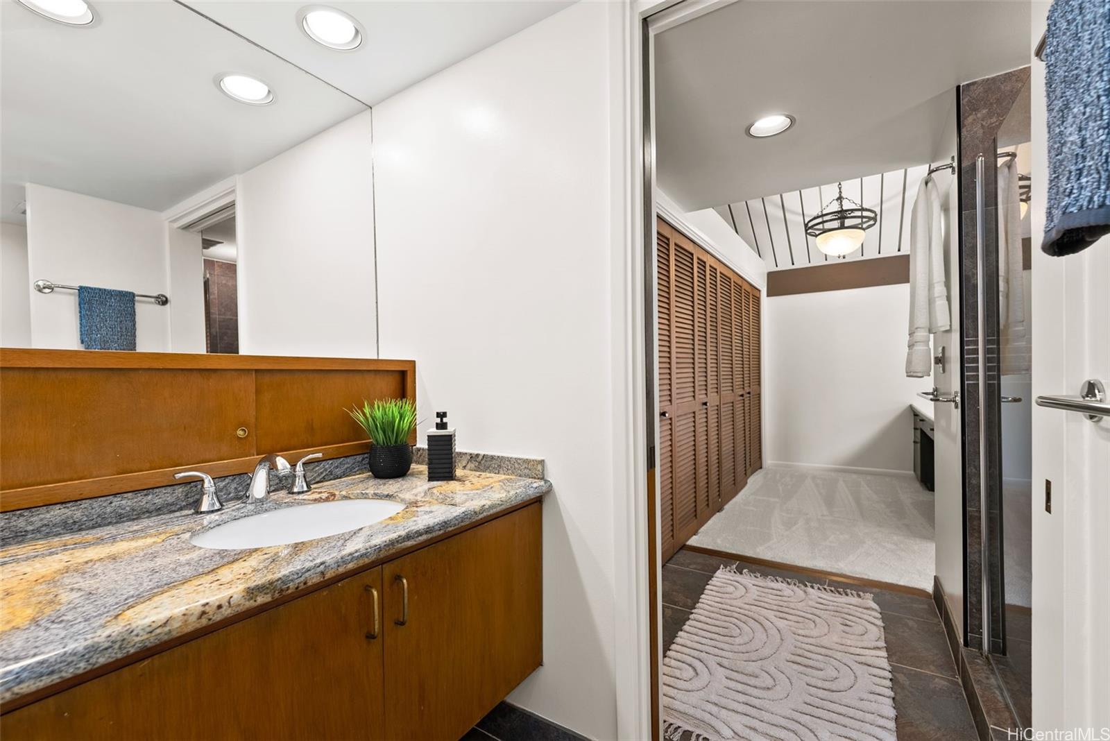 156 Forest Ridge Way Honolulu, HI 96822 - Photo 17 of 25 a bathroom with a granite countertop sink and a mirror