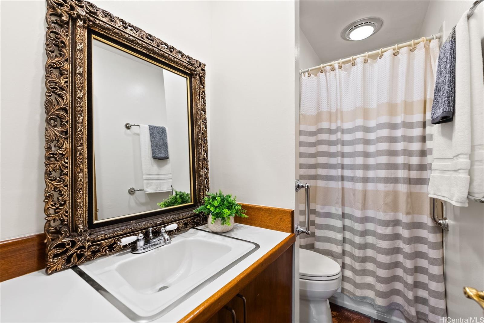 156 Forest Ridge Way Honolulu, HI 96822 - Photo 21 of 25 a bathroom with a sink toilet and mirror