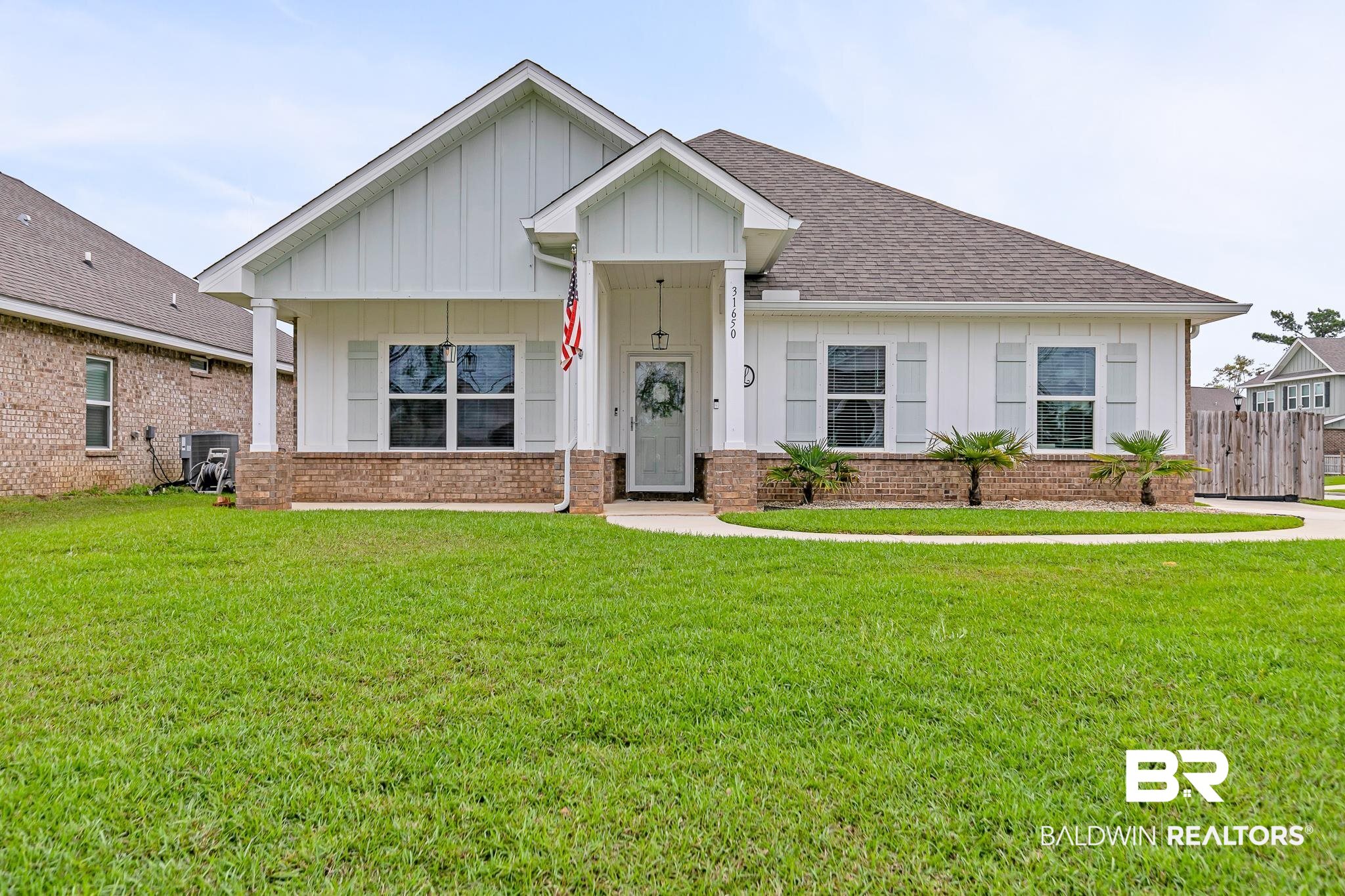 31650 Memphis Loop Daphne, AL 36527 - Photo 2 of 68 View of front of house featuring board and batten siding, a front lawn, and roof with shingles
