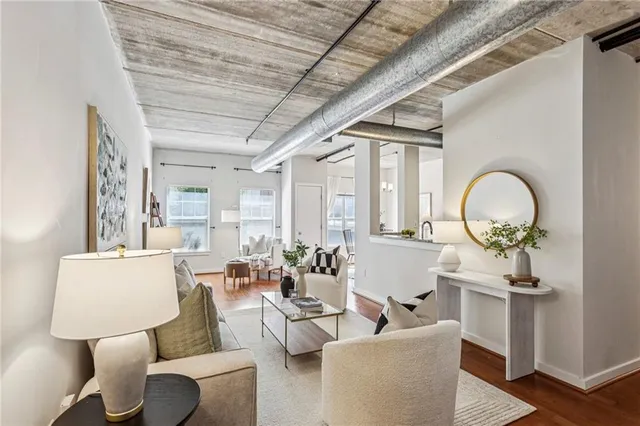 a living room with furniture a mirror and a large window