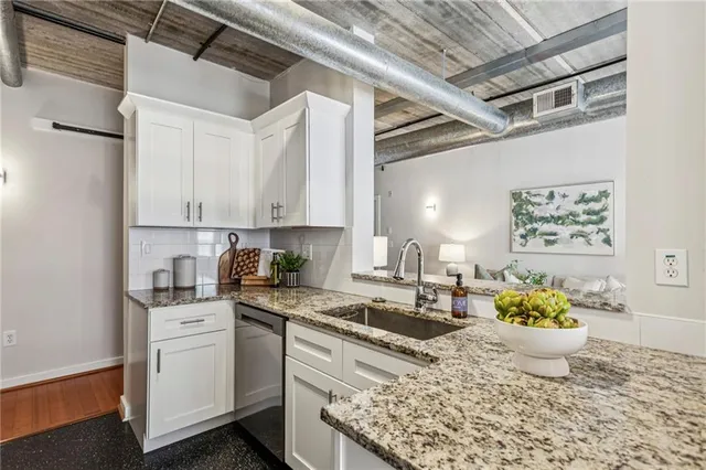 a kitchen with white cabinets and sink
