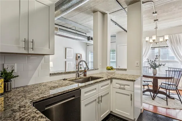a kitchen with granite countertop a sink stainless steel appliances white cabinets and a granite counter tops