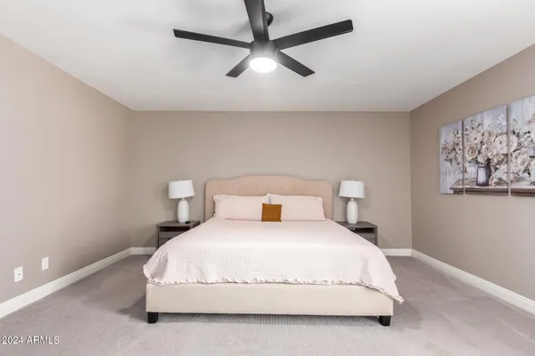 a bedroom with a bed and painting on the wall