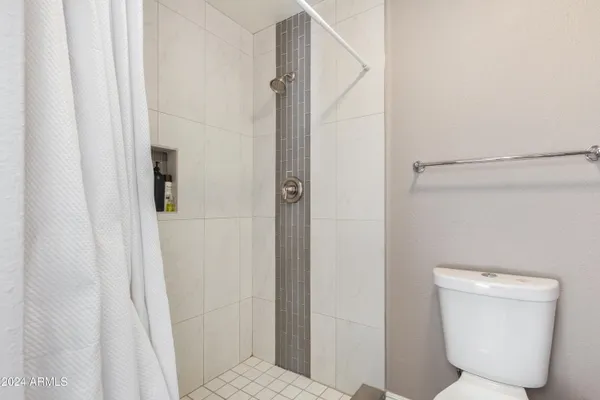 a bathroom with a toilet and a shower