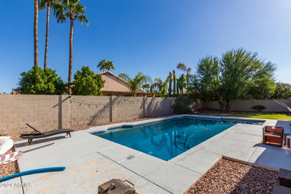 a view of house with swimming pool and furniture