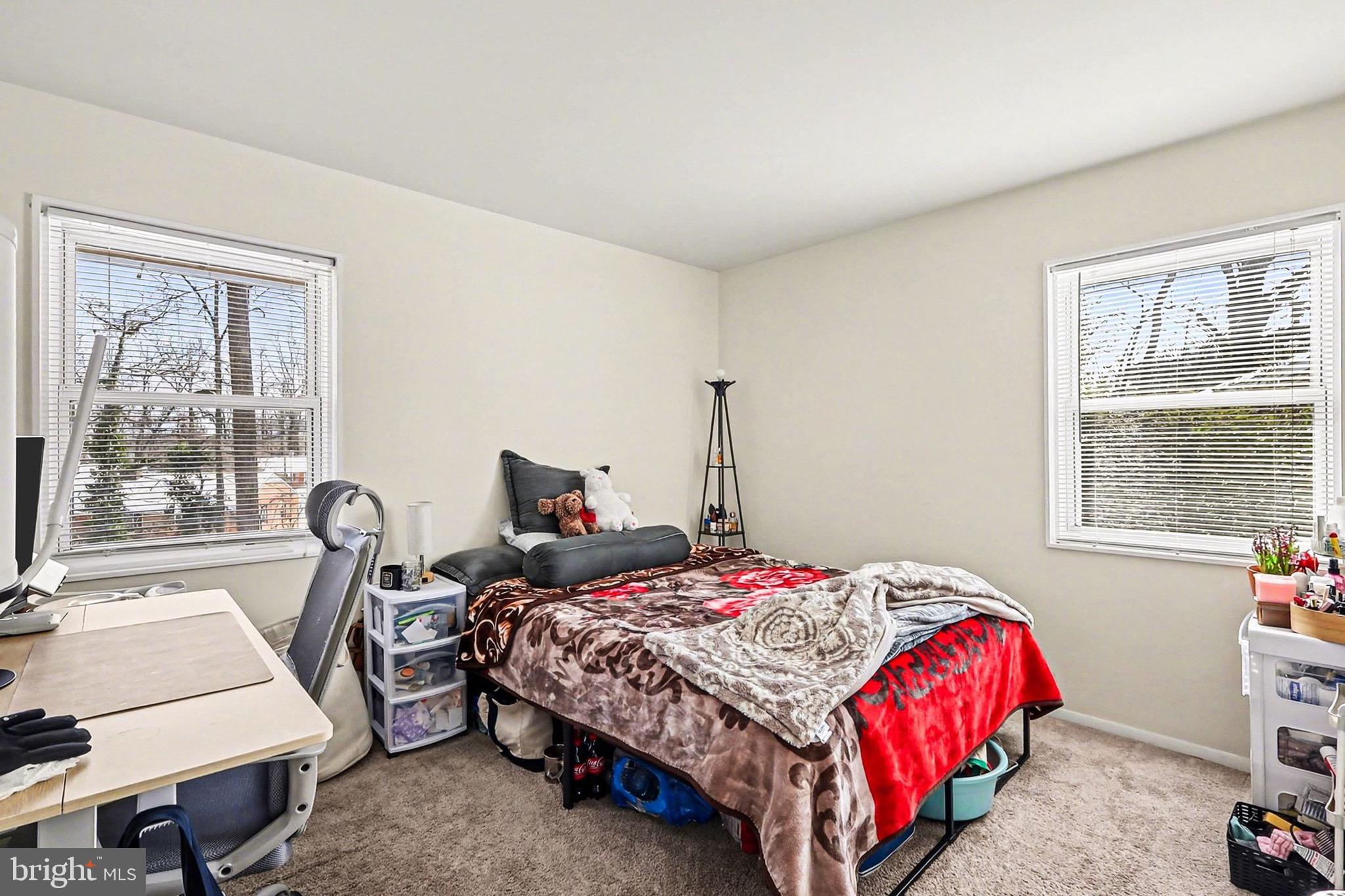 7112 Dalhouse Street Springfield, VA 22151 - Photo 13 of 25 a bedroom with a bed a table and with a large window