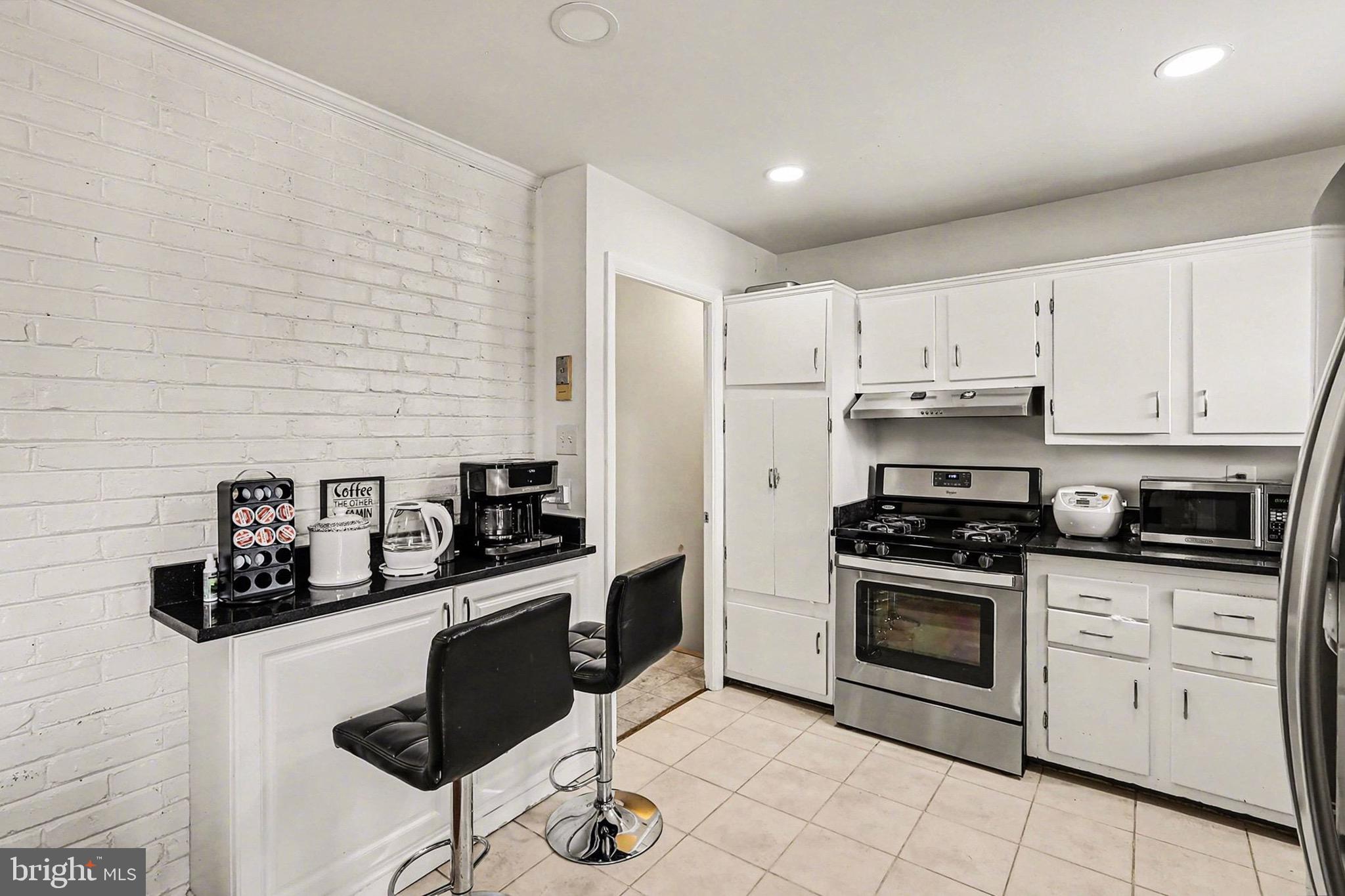 7112 Dalhouse Street Springfield, VA 22151 - Photo 5 of 25 a kitchen with granite countertop white cabinets and appliances