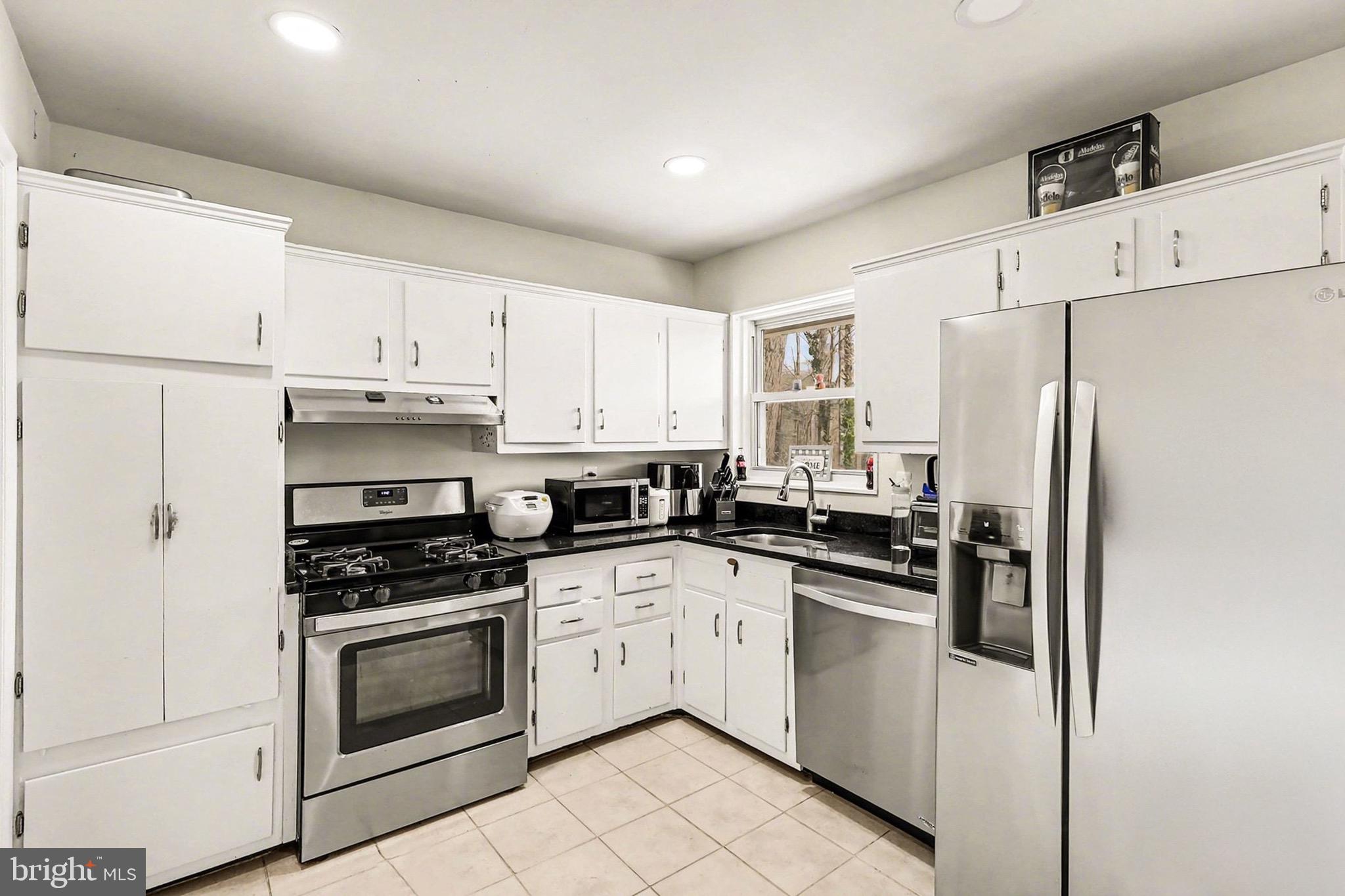 7112 Dalhouse Street Springfield, VA 22151 - Photo 6 of 25 a kitchen with cabinets stainless steel appliances and a window