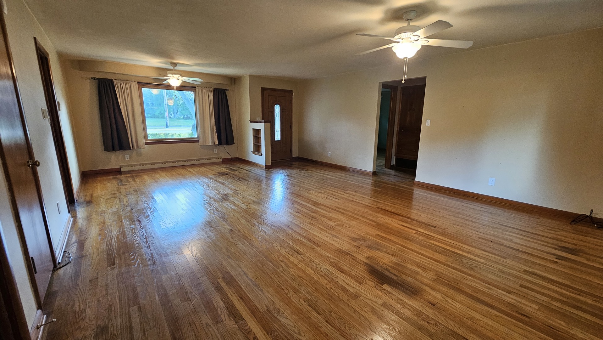 13658 East Flagg Road Rochelle, IL 61068 - Photo 8 of 65 an empty room with wooden floor and ceiling fan