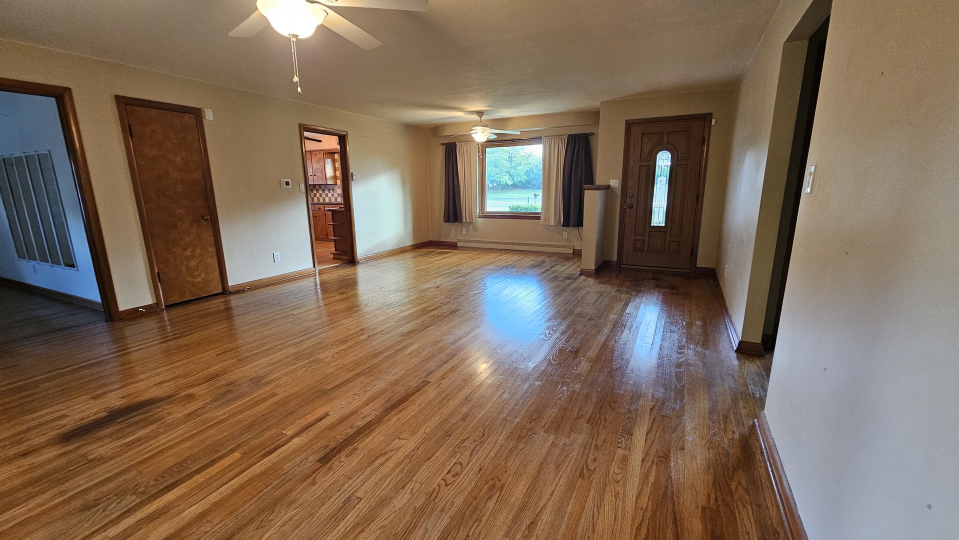 13658 East Flagg Road Rochelle, IL 61068 - Photo 9 of 65 an empty room with wooden floor and fireplace