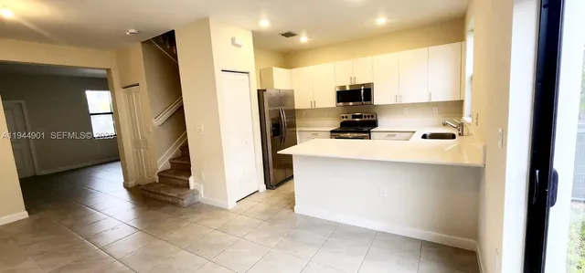 a kitchen with stainless steel appliances a refrigerator sink and microwave