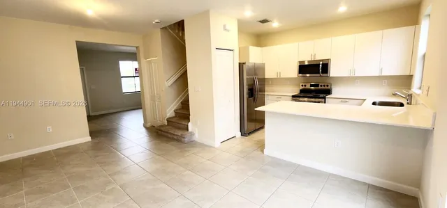 a kitchen with stainless steel appliances a refrigerator a stove a sink and a microwave