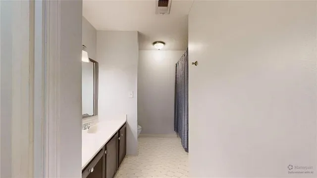 a bedroom with a bed and a flat tv screen on dresser